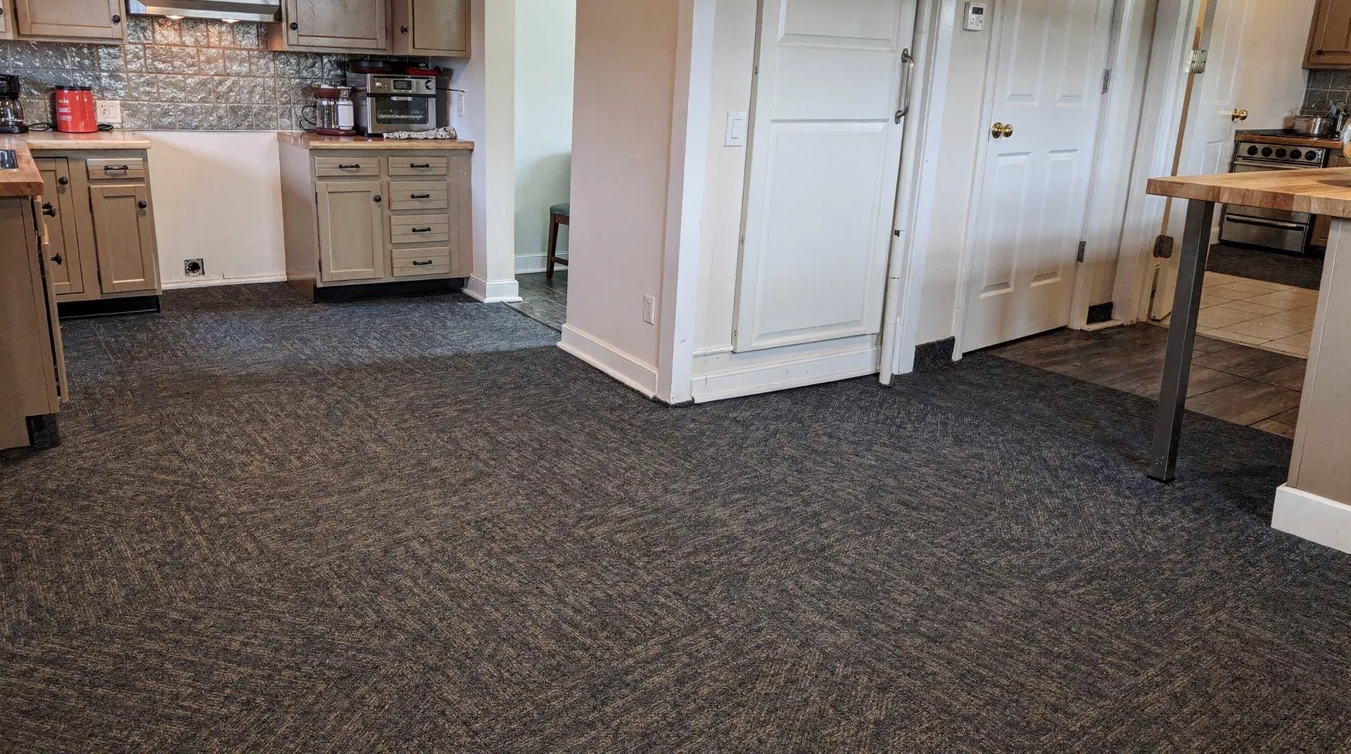 Commercial carpet tiles in a kitchen setting, demonstrating design flexibility and stain resistance.